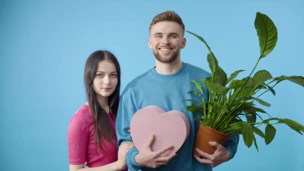 Junger Mann Und Frau Mit Pflanze Und Herz Auf Blauem — Stockvideo