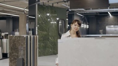 Kadın sergi salonundan fayans seçiyor.