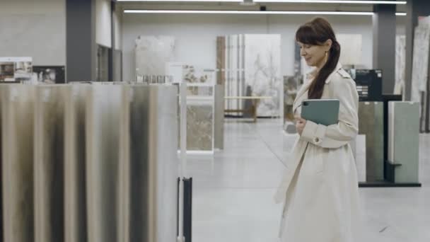 Mujer Abrigo Ligero Con Tableta Caminando Sala Exposición Azulejos — Vídeos de Stock