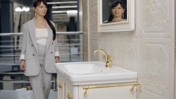 妇女走进瓷砖陈列室靠近水池的浴室 — 图库视频影像