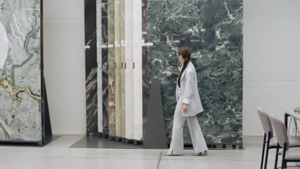 Женщина Идущая Перед Мраморной Стеной Кафельном Салоне — стоковое видео