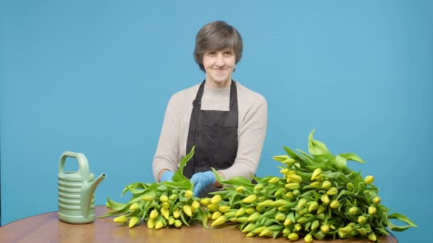 Mujer Pie Detrás Mesa Con Tulipanes Amarillos Regadera — Vídeo de stock