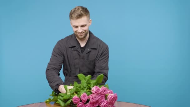 Seorang Pria Hati Hati Mengambil Mawar Merah Muda Dari Meja — Stok Video