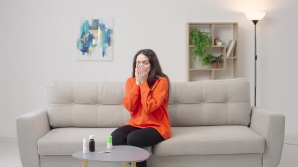 坐在沙发上戴围巾的年轻女子嗓子疼 嗓子疼 — 图库视频影像