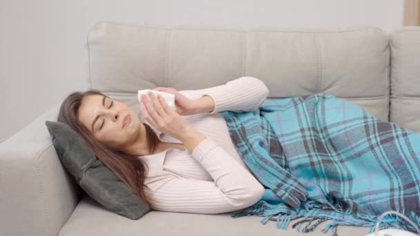 生病的年轻女子打喷嚏时 鼻涕喷出 生病的女孩得了流感或感冒 有过敏症状 — 图库视频影像
