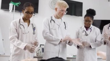 İlk yardım kursuna giden bir grup doktor klinikte tıbbi eldiven taktılar.