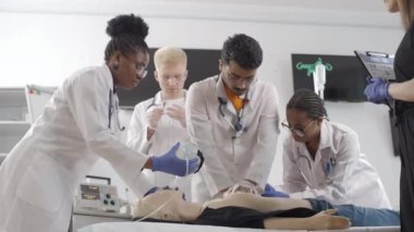 Bir grup doktor klinikte mankenler üzerinde inceleme yapıyor.