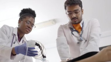 Tıbbi klinikteki ilk yardım kursunda beyaz önlüklü ve eldivenli sağlık uzmanları
