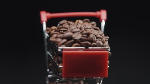 光の動きと暗い背景にコーヒー豆がいっぱいのショッピングトロリーを回転させる映像 — ストック動画