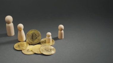 Altın bitcoin paraların ve gri arkaplanda tahta figürlerin yakın çekimi. Dijital para birimleri BTC şifreleme para birimi