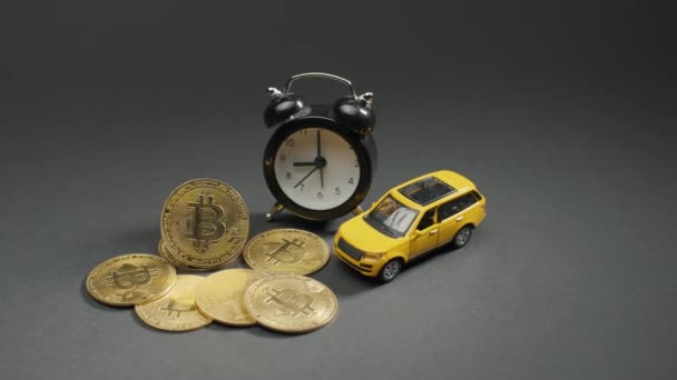 Sarı Arabası Saati Olan Gri Bir Tahtadaki Bitcoin Kripto Sikkesi — Stok video