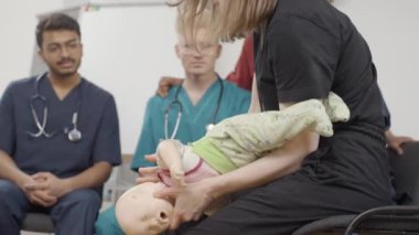 İlk yardım. Bebek klinikte doktor tarafından tutuluyor.