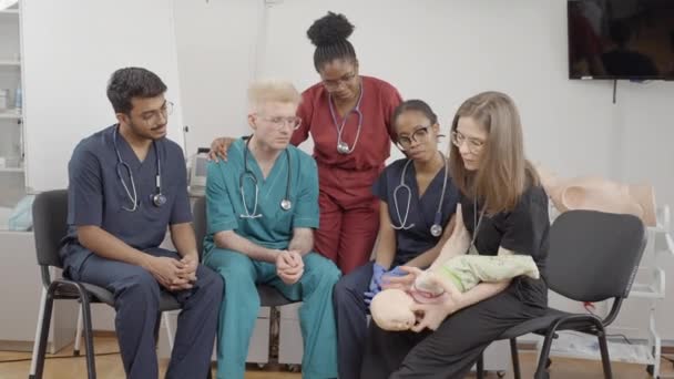 ファースト エイド 医学クリニックで乳児を診察する医師団 — ストック動画