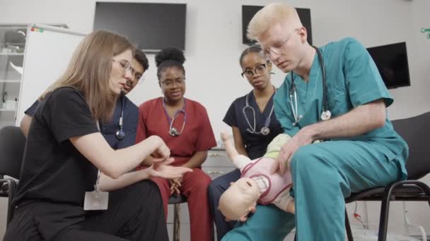 Первая Помощь Группа Врачей Осматривающих Младенца Медицинской Клинике — стоковое видео