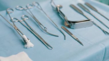 Ameliyat için tıbbi gereçler masada. Ameliyat için cerrahi aletler hazırlanıyor. Neşterler, forseps ve cımbız. Ameliyat ya da acil durum ve ambulans ya da tedavi kavramı