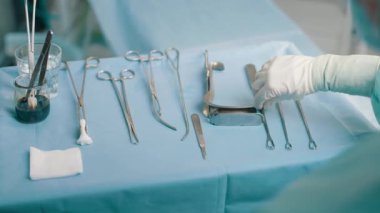 Ameliyat için tıbbi gereçler masada. Ameliyat için cerrahi aletler hazırlanıyor. Neşterler, forseps ve cımbız. Ameliyat ya da acil durum ve ambulans ya da tedavi kavramı