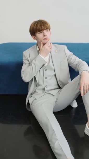 Junger Mann Anzug Sitzt Auf Blauem Sofa — Stockvideo