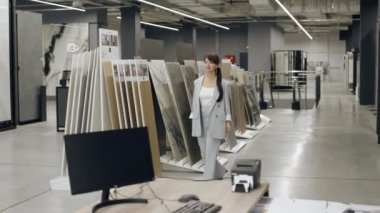 Sergi salonundaki masaya doğru yürüyen kadın.