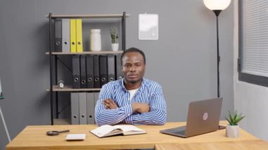 Genç özgüvenli Afro-Amerikan profesyonel iş adamı başparmağını kaldır ve ofisteki kameraya bak.