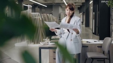 Kadın tasarımcı bir kuaförde fayans örneklerini inceliyor