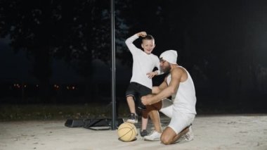Baba oğul basketbol oynarken yerel bir sahada birbirlerine bağlanırlar.
