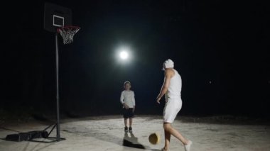 Baba ve oğul, yavaş çekimle basketbol antrenmanının tadını çıkarıyorlar.