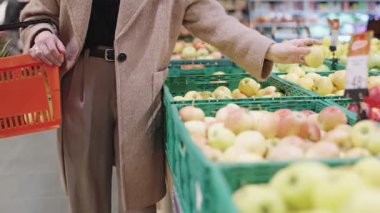 Süpermarkette taze ürünleri keşfeden kız alışveriş deneyimini yakalamak için yavaş çekim kullanıyor.
