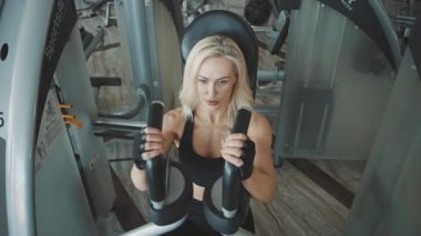 Kız spor salonunda egzersiz yapmak için yavaş çekim tekniklerini kullanıyor.