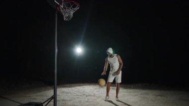 Parlak ışıkların altında yavaş çekimde basketboldan hoşlanan bir adam