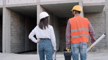 İnşaat işçileri inşaat sahasındaki bir proje sırasında ağır çekimde iş birliği yapıyorlar.