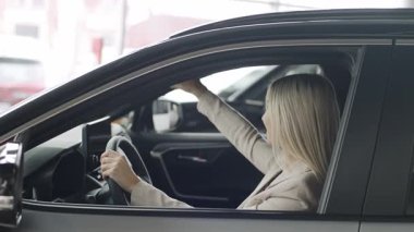 Kadın yavaş çekimde stile ve özelliklere odaklanmış bir arabayı galeride keşfediyor.