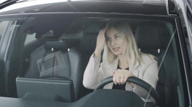 Canlı bir sergi salonunda modern bir arabanın lüksünden zevk alan bir kadının zarafetini tecrübe edin.