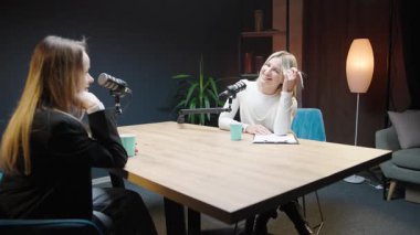 Podcast stüdyosunda bir kadın girişimciyle iş stratejileri üzerine tartışma.