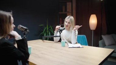Konforlu bir podcast stüdyosunda iş görüşleri ve kişisel gelişim üzerine sohbet.