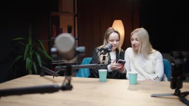 Sıcak bir stüdyoda mikrofonlu iki kadın arasında podcast tartışması