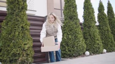 Evindeki bir kadına teslimat var. Çevresi yemyeşil.