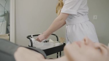 Uzman kadın, sakin bir güzellik stüdyosunda ağır çekimde kalıcı kozmetik tedavi uyguluyor.