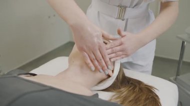 Ağır çekimde kozmetoloji tedavisi bir kadının güzellik maskesi uygulamasını gösteriyor.