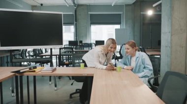 Proje ayrıntılarını tartışan ve bir belge üzerinde işbirliği yapan profesyonellerle ofiste yapılan iş toplantısı