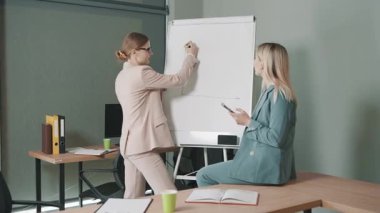 Ofis ortamında proje fikirleri ve stratejileri tartışan iki profesyonelle iş toplantısı