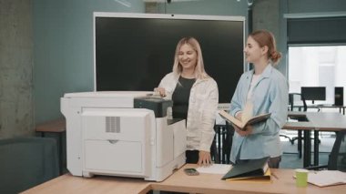 İş adamları, ofis ekipmanlarını kullanırken modern ofis ortamında proje belgelerinde işbirliği yaparlar.