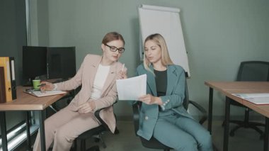 Proje belgelerini ofis ortamında tartışan profesyonellerle iş toplantısı devam ediyor