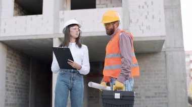 İnşaat işçileri proje detaylarını şehir şantiyesinde gündüz saatlerinde tartıştılar