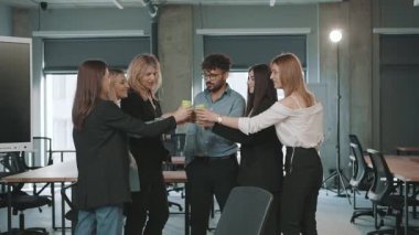 İş ekibi modern ofiste başarılı proje tamamlanışını neşeli bir tostla kutluyor