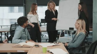 İş stratejisi ve veri analizi üzerine bir sunumla bir ofis ortamında takım işbirliği