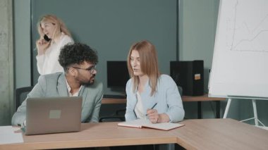 Ekip, verileri analiz ederken ve proje stratejilerini yavaş çekimde tartışırken bir ofiste işbirliği yapar.