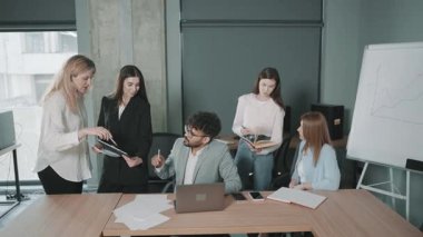 Modern ofiste ortaklaşa yapılan ekip toplantısı proje belgelerini yavaş çekimde tartışıyor.