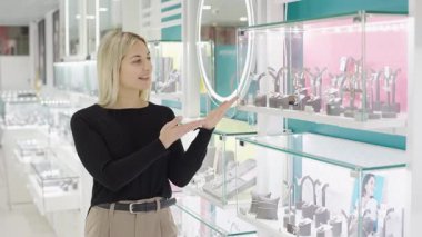 Ağır çekimde mücevher sergisi mağazada altın, gümüş ve elmas parçaları sergiliyor.