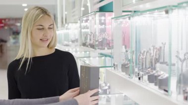Yavaş çekim efektleri olan şık bir mağazada zarif mücevher seçimleri keşfediyor.