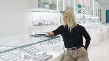 Modern bir mağazada mücevher alışverişi deneyimi altın, gümüş ve elmas parçaları sergiliyor.